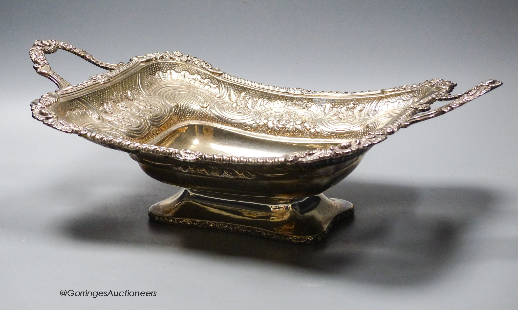 A late George III silver two handled bread dish, embossed with foliate scroll decoration, by Charles Price, London, 1817, 39.5oz.